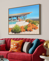 Stylish living room with mid-century modern decor, adorned with artwork depicting the Stahl House and a woman relaxing poolside in a chic floppy hat and bikini