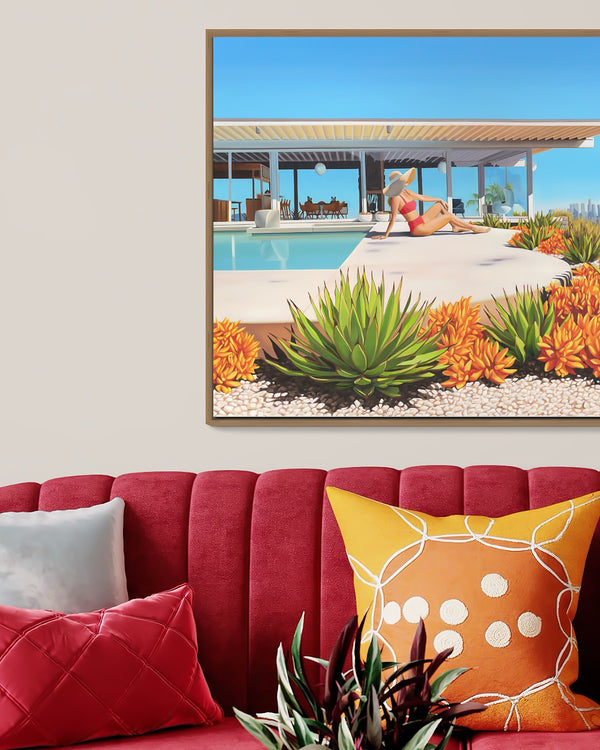 "Sunny mid-century modern living room with poolside view of the Stahl House and Los Angeles skyline, accentuated by a woman in a fashionable wide-brimmed hat and bikini