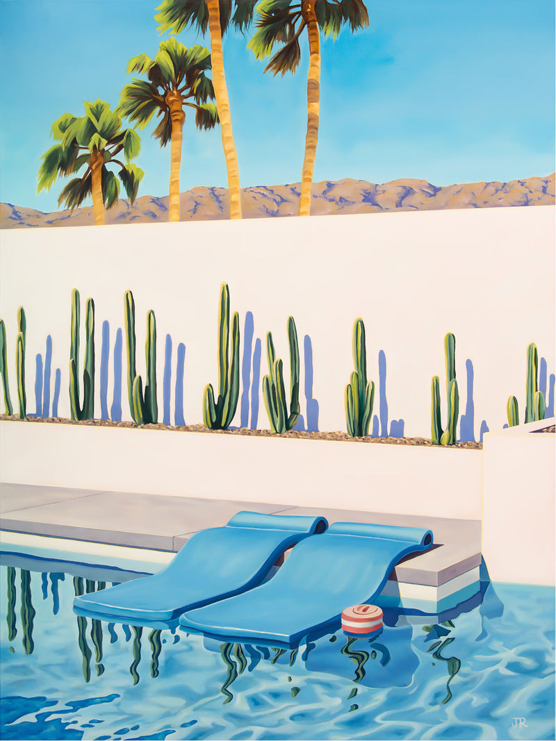 Brightly colored pool floats create a playful contrast against the warm, desert landscape of Palm Springs